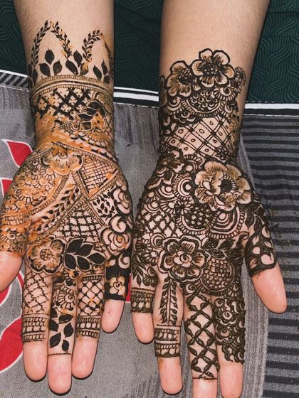 A beautiful example of a mixed-style design, combining leafy cuffs with intricate floral and geometric patterns on the palms. The contrast between the two hands is stunning.