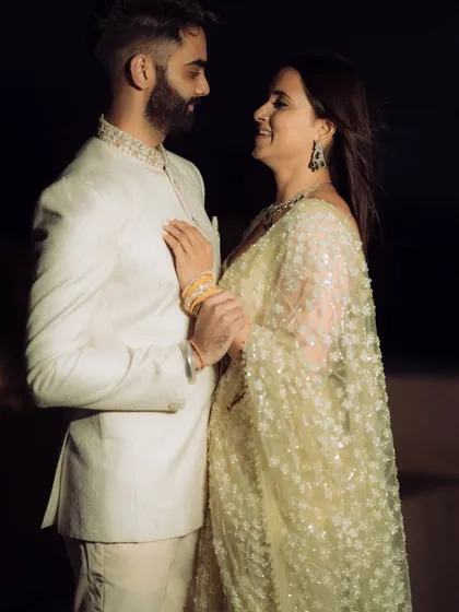 A dramatic, high-fashion pose against a dark background. This shot from a rooftop engagement in Mumbai highlights the couple's stylish outfits and creates a modern, edgy, and cinematic feel.
