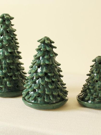 This set of three Coniferous Christmas tree luminaries comes in varying heights, perfect for creating a festive centerpiece on your holiday table.