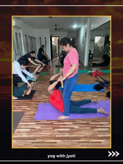 A student receives a hands-on assist in a deep back-opening stretch, helping to release tension in the spine.