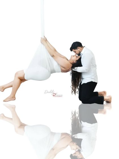 A stunning black and white artistic portrait of a couple. The suspended pose and reflection create a powerful and symbolic image of support and love.
