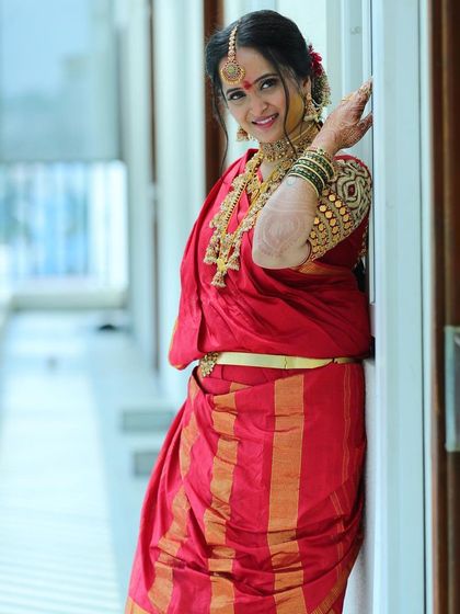 A classic pose for my beautiful Iyer bride. Her makeup features a soft, golden glow and defined eyes, perfectly complementing her red nine-yard saree and traditional gold jewellery.