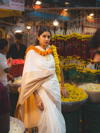 Surrounded by flowers, this shot feels both vibrant and serene. The composition places the model right in the heart of the market's beauty.