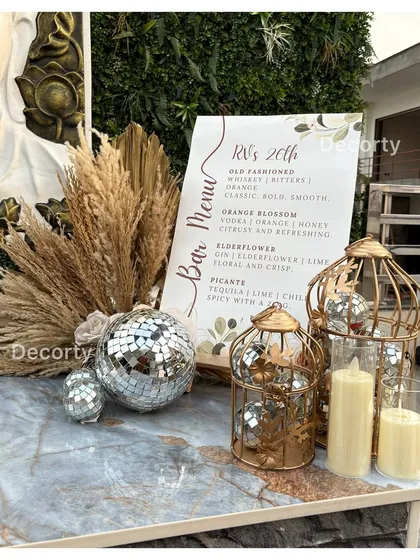 A close-up of the bar area from the disco-themed party, showing a custom bar menu and decorative disco balls in golden birdcages.