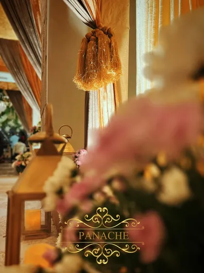 A detail shot of the decor elements, including a golden tassel tie-back and a floral arrangement with candle-lit lanterns. These small details contribute to the overall luxurious feel.