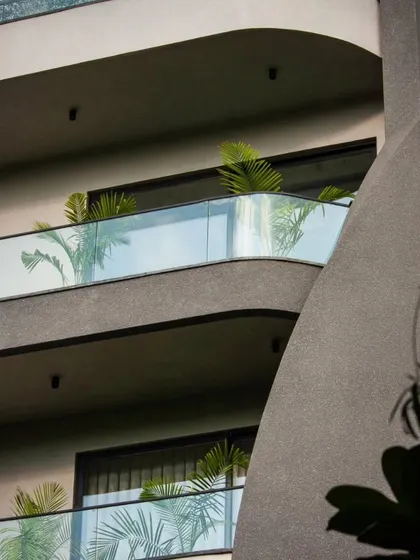 This detail shot of the Lotus Villa shows the fluid lines of the balconies against the textured concrete. The design adds greenery to soften the form and create a connection with nature.
