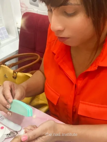 This student is learning how to properly prep the nail, including clipping and filing, for a manicure or extension service.
