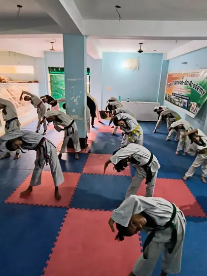 Students performing a standing side bend stretch during their warm-up routine.
