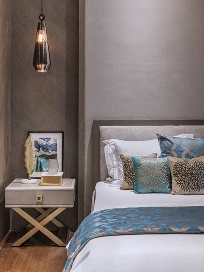 This bedroom design is a distinct fusion of splendour and comfort. We created a visual contrast between deep blue furnishings and all-pervasive wooden elements. Bespoke pendant lights and sculptural decor accents add character to the interiors of this Bandra residence.