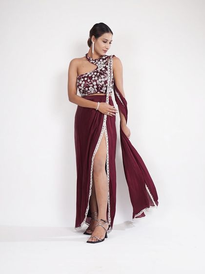 A full-length shot of the wine-colored Indo-Western outfit. The thigh-high slit and one-shoulder top make it a bold and modern choice.