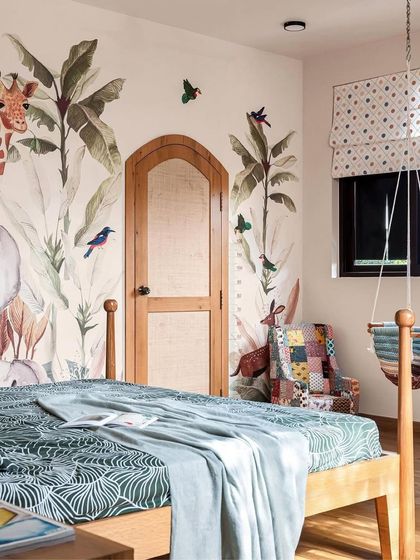 This kids' bedroom, featured in a magazine, highlights the jungle-themed wallpaper and the custom arch-shaped rattan door. It's a perfect example of creating a playful yet stylish space for children.