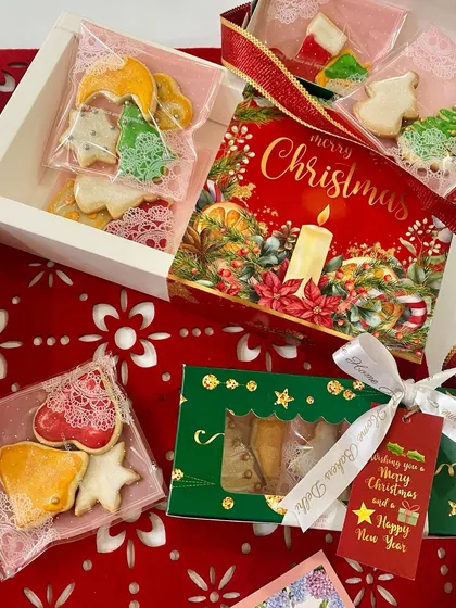 Our Christmas cookie gift boxes come beautifully packaged with festive cards and ribbons. Here you can see a few different packaging options, from window boxes to small pouches, perfect for stocking stuffers.