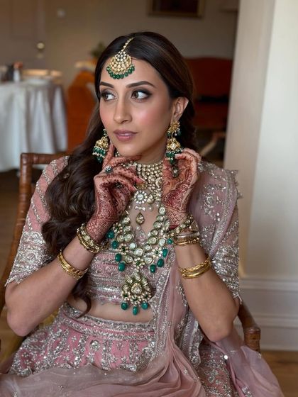 A candid getting-ready shot that captures the beautiful details of her jewelry and the soft, romantic makeup.