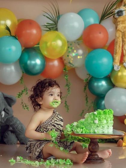 Our jungle theme is a wild adventure. This little explorer is having the best time getting his hands messy with this vibrant green cake.