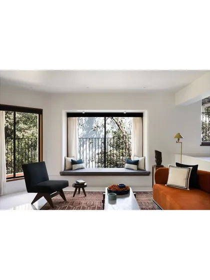 Our design for this multilevel home connects the living and dining areas while giving each its own identity. The split-level layout and cozy bay window seating create interesting visual layers and dedicated zones for relaxation.