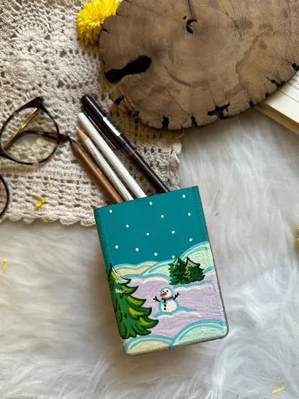 The winter side of the pen stand, featuring a snowy landscape and a cute snowman.