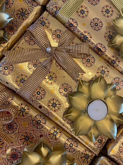 A close-up of the intricate golden wrapping paper and ribbon detail on our corporate Diwali boxes.