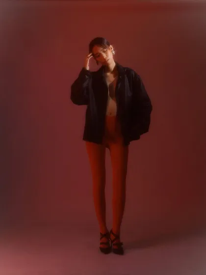 A full-length shot where the simple, clean makeup and hair support the minimalist but striking fashion concept.