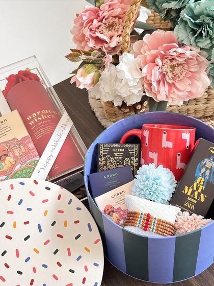 A fun and colorful Rakhi hamper for a little brother, featuring a quirky coffee mug, Zara perfume, and Carra chocolates in a multi-purpose storage box.