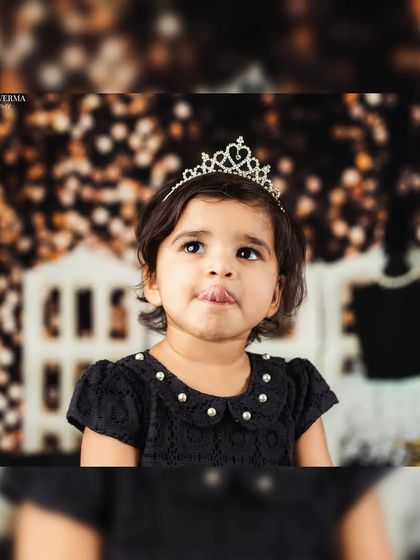 A close-up portrait of a toddler girl sticking her tongue out playfully, showing her fun personality during the chic photoshoot.