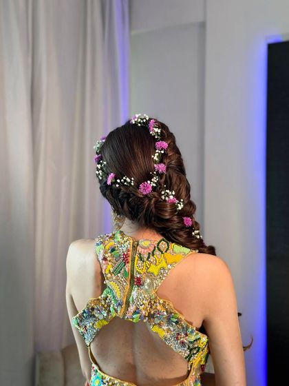 The back view of the side braid showcases the intricate weaving and the beautiful distribution of flowers throughout the hair.
