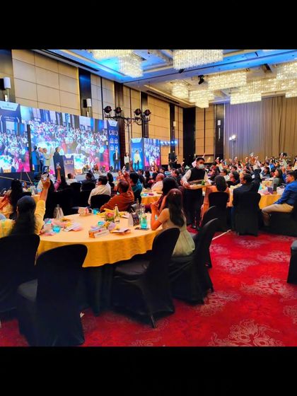 A wide shot of the ballroom during the Emerson event, with the audience engaged in the live sand art show.
