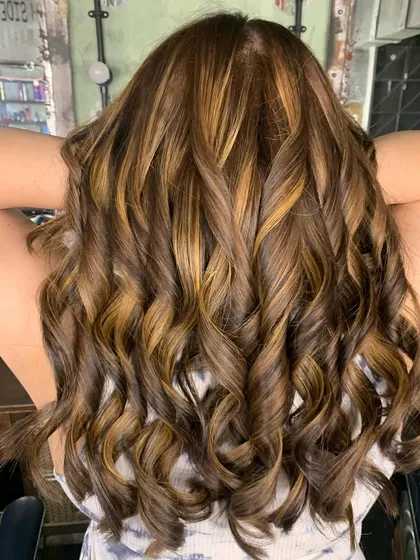 A stunning color correction. This client had a lot of previous dark color build-up, and we transformed it into this beautiful, sun-kissed look using a bleach and tone technique.
