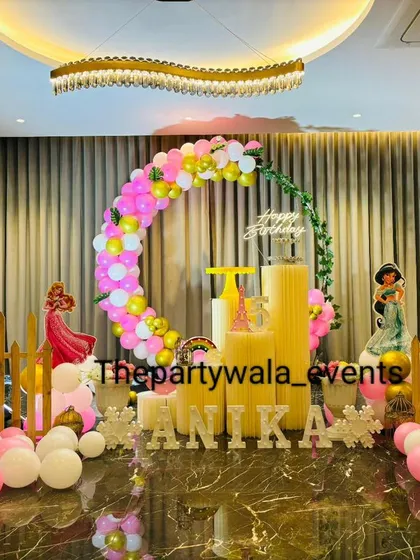 A wide view of a princess party setup in a large hall. The balloon arch and props create a beautiful focal point on the marble floor, showing how I can transform any space.