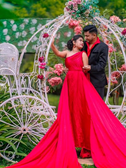 A glamorous couple in red and black by the Cinderella carriage, showcasing a bold and dramatic take on the fairytale theme.