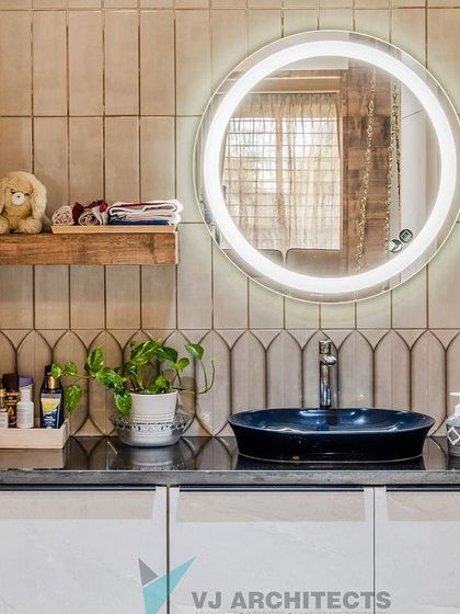 Even the bathroom vanity reflects the home's fusion theme. A modern, vessel-style sink in a bold blue is set against a backdrop of uniquely shaped tiles, complemented by a backlit circular mirror for a contemporary feel.