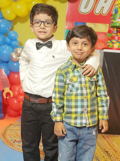 The birthday boy with his friend at the LEGO-themed party, ready to celebrate.