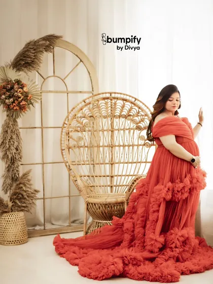 A quiet, contemplative pose by the window. The natural light softly illuminates the mom-to-be in her stunning red gown, creating a beautiful, fine art portrait.