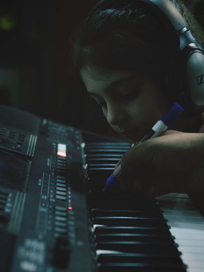 A teacher helps a young student mark notes on the keyboard. This hands on approach helps build a strong foundation.