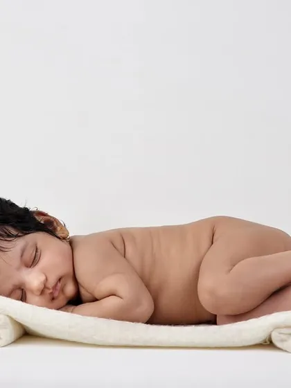 The classic "tushy up" pose is a favorite for newborn photography. It showcases the baby's tiny back rolls and curled-up posture, reminding you just how small they once were.