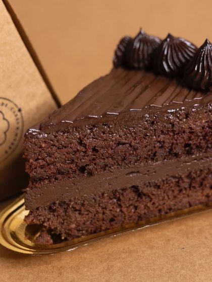 A close-up of a slice of my low-carb Ultimate Chocolate Cake. You can see the moist almond flour sponge and the rich layers of sugar-free chocolate fudge. It's the perfect treat for any diabetic or keto diet follower.