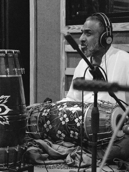 A black and white shot of Jayachandra Rao on mridangam during a rehearsal. His expressive face shows his deep connection to the rhythm.