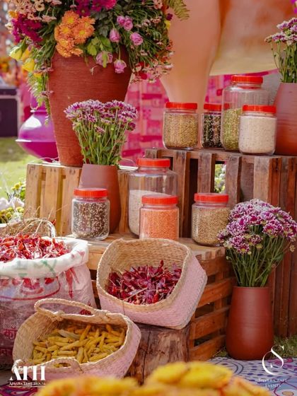 A close-up of a rustic decor corner. Jars of spices and baskets of dried chilies are arranged on wooden crates, adding an authentic and sensory element to the bazaar-themed event.