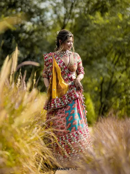 A beautiful portrait of the bride in a field of tall grass during her Mehendi day. The natural setting and golden light make her colorful outfit pop.