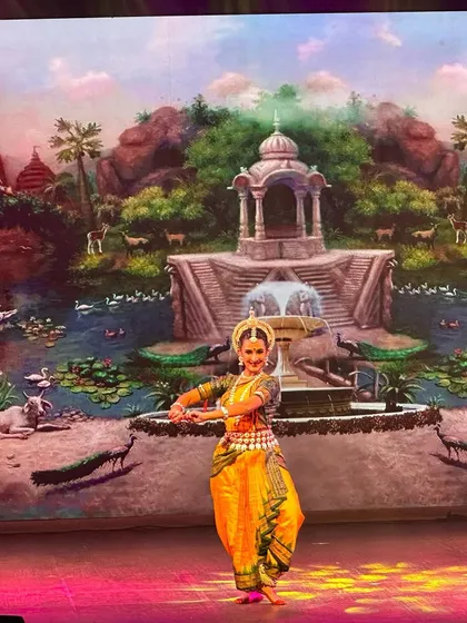 The stage backdrop is a canvas. Here, a beautifully painted scene of a traditional Indian landscape sets the stage for a graceful Odissi performance, which I had the honor of directing.