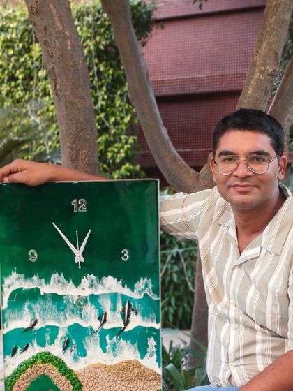 This is me with another ocean clock, a popular design in my workshops. The green resin represents the deep sea, with waves crashing on a sandy shore.