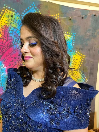 A close-up of the beautiful curls and dramatic eye makeup. This look is perfect for someone who wants to stand out.