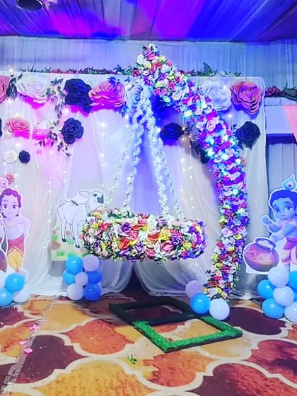 The Krishna-themed naming ceremony setup with blue lighting, giving the flowers and props a magical glow.