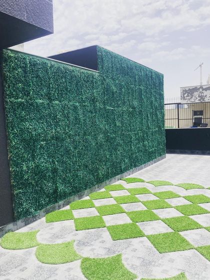 To add privacy and a wall of green to this terrace, I installed a floor-to-ceiling artificial vertical garden. This solution is low-maintenance and provides a vibrant green backdrop to the space year-round.