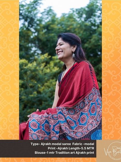 A happy customer smiling in her red Ajrakh modal saree. The intricate block-printed pallu adds a touch of artistry to this classic piece.