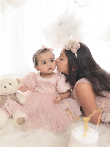 A sweet kiss from big sister. These are the unscripted, loving moments that families will cherish forever.