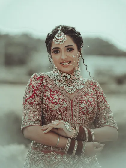 The joy of a bride shines through in her smile. This is a beautiful, candid-style portrait that captures her happiness and the exquisite details of her wedding jewelry and attire.
