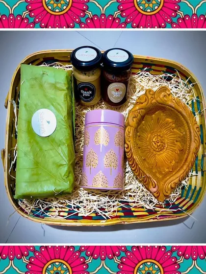 A look inside one of my festive gift baskets. This hamper includes a loaf of my bread wrapped in a banana leaf, jars of nut butter, and a traditional diya, all nestled in a beautiful woven basket.