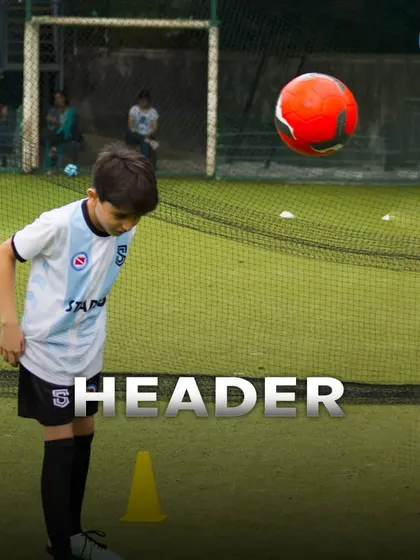 A young player practices a header, a crucial skill in football. Safety and proper technique are my top priorities during these advanced drills.