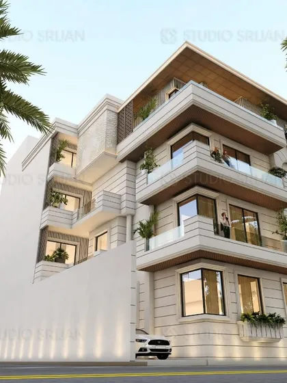 A corner residence in Kirti Nagar designed with neoclassical elements. The corner is articulated with bay windows and decorative moldings, while the rest of the facade maintains a clean, stone-clad appearance.