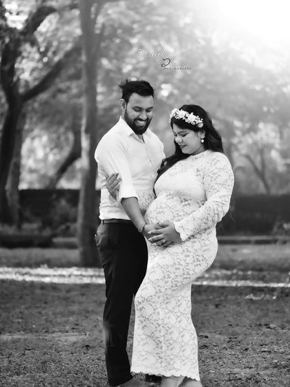A tender black and white moment between an expecting couple outdoors. The soft focus and natural light create a dreamy and romantic atmosphere for this pregnancy portrait.
